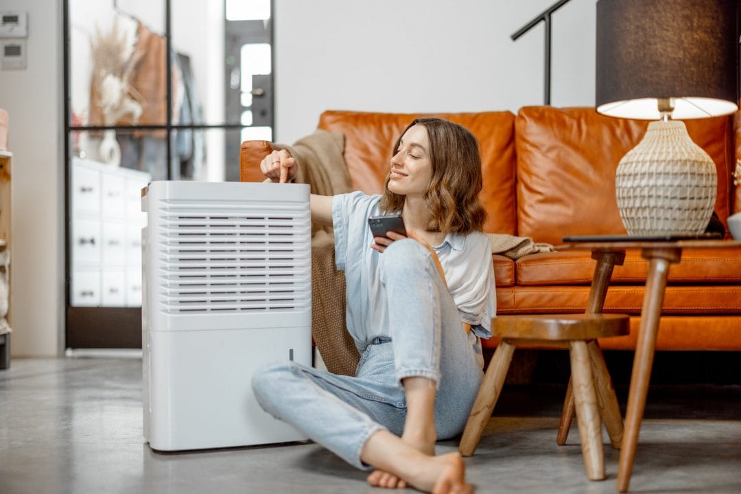 woman-sitting-near-air-purifier-and-moisturizer-appliance.
